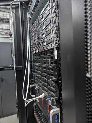 Vorderansicht mehrerer Server in einem 19-Zoll-Rack. Man erkennt viele Festplatteneinschübe mit grün leuchtenden LEDs.